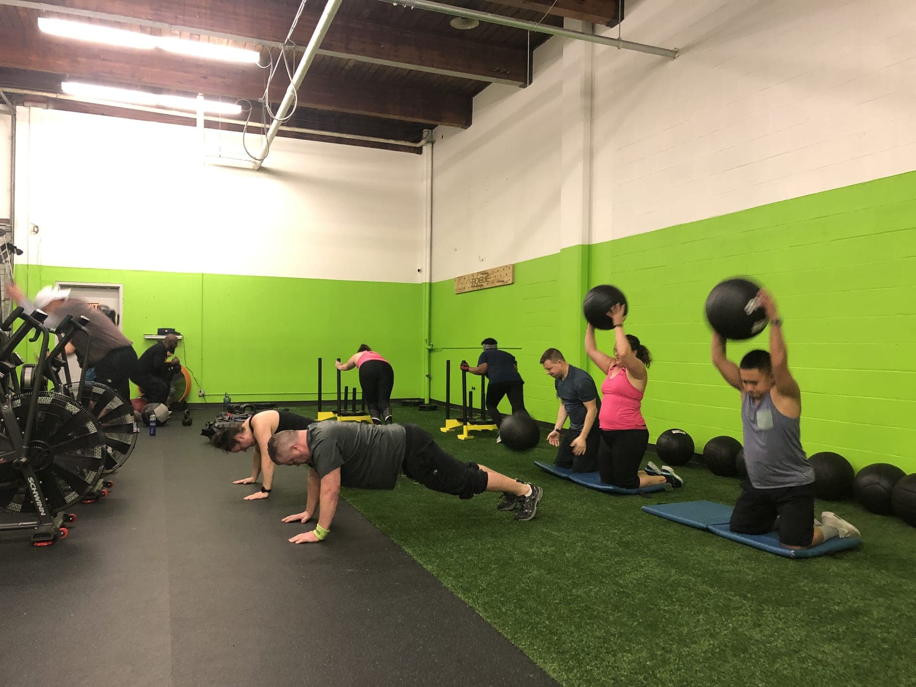 A Team Training session, with clients doing push-ups and medicine ball slams